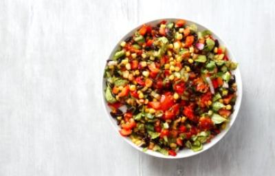 Ensalada marroquí tradicional con ingredientes frescos Ensalada marroquí colorida con tomate, maíz, pimiento y hierbas frescas