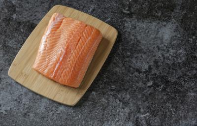 Filete de salmón fresco, uno de los tipos de salmón más usados Filete de salmón fresco sobre tabla de madera