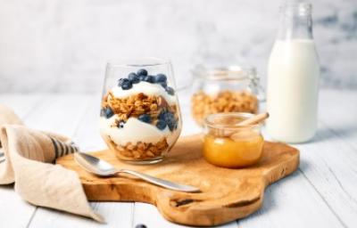 Desayuno saludable para alimentarse bien dentro y fuera de casa. Granola con yogurt griego y miel para alimentarse saludablemente.