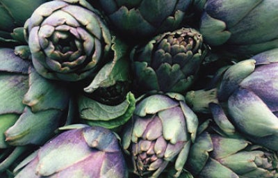 Alcachofas frescas verdes y moradas en primer plano, perfectas para conocer mejor para qué sirve la alcachofa en recetas