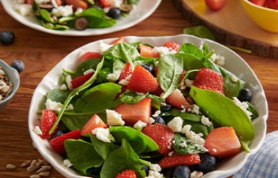 Persona vertiendo vinagre de arroz en ensalada agridulce.