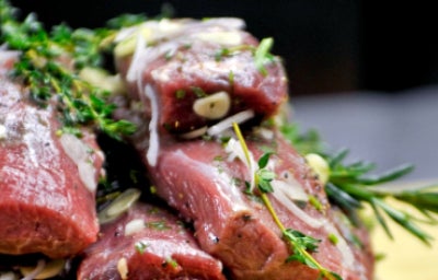 Lomo de cordero con adobos de romero, tomillo, ajo y aceite de oliva virgen extra, listo para la parrilla.