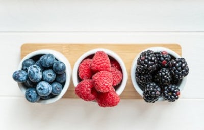 Mezcla de frutos silvestres, frambuesas, arándanos y moras aisladas sobre fondo blanco.
