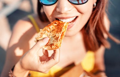 Mujer comiendo quesadilla con queso morolique.