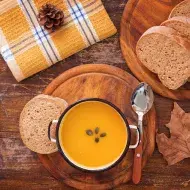 Una de las mejores recetas con zapallo es una crema, acompañada con pan.