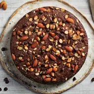 Torta de chocolate decorada con almendras sin pelar enteras y trituradas  