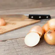 Se pueden usar distintos tipos de corte en la cebolla, como juliana o rodajas. Cebollas sobre una mesa, listas para cortar en julianas o rodajas.