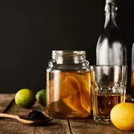 Frutas cítricas, botellas y vasos con kombucha Frutas cítricas, botellas y vasos con kombucha