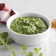Salsa verde y sus ingredientes en un recipiente blanco