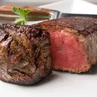 Carne Angus asada con hojas de perejil en un plato 