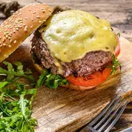 Hamburguesa de queso abierta con cubiertos 