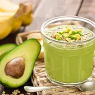 Aguacate partido a la mitad con un batido de cereal y verduras para desintoxicar el cuerpo