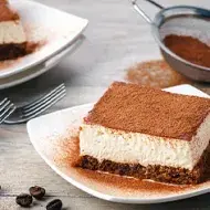 Tiramisú con café espolvoreado, uno de los postres fáciles y rápidos con pocos ingredientes que se pueden prepara