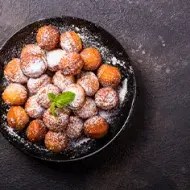Plato de buñuelos de yuca espolvoreados vistos desde un ángulo cenital