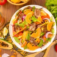 Ensalada de frutas y lechuga con papaya, tomate, cebolla y carne