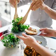 Persona sirviendo ensalada de escarola fresca en plato