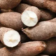 Montón de ñames apilados con dos de ellos cortados a la mitad.