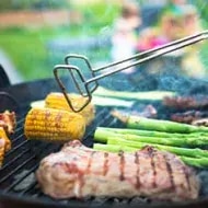 Filete de carne asada con choclo, chorizo y vegetales sobre parrilla volcánica.