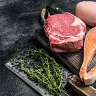 Hay varios tipos de carne magra, desde el filete de salmón hasta la pechuga de pollo. Distintos tipos de carne magra en la mesa listos para asar
