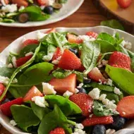 Persona vertiendo vinagre de arroz en ensalada agridulce.