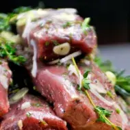 Lomo de cordero con adobos de romero, tomillo, ajo y aceite de oliva virgen extra, listo para la parrilla.