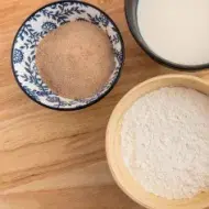 Almidón de yuca, harina y leche. Cuenco decorativo de bambú y negro. Plato giratorio de madera. Vista superior.