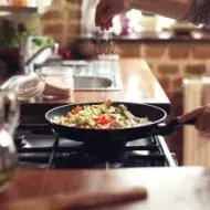 Cocinar verduras, condimentando con ajonjolí.