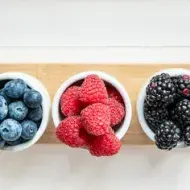Mezcla de frutos silvestres, frambuesas, arándanos y moras aisladas sobre fondo blanco.