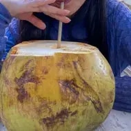 Mujer disfrutando de agua de pipa.