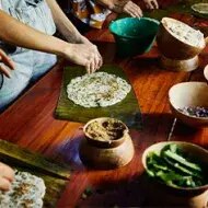 Familia preparando tamales en Latinoamérica de forma tradicional.