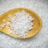 Sal artesanal sobre cuchara de madera.