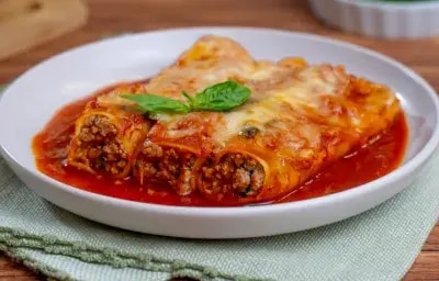 Canelones rellenos de carne molida al horno con salsa roja y queso gratinado