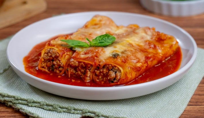 Canelones rellenos de carne molida al horno con salsa roja y queso gratinado
